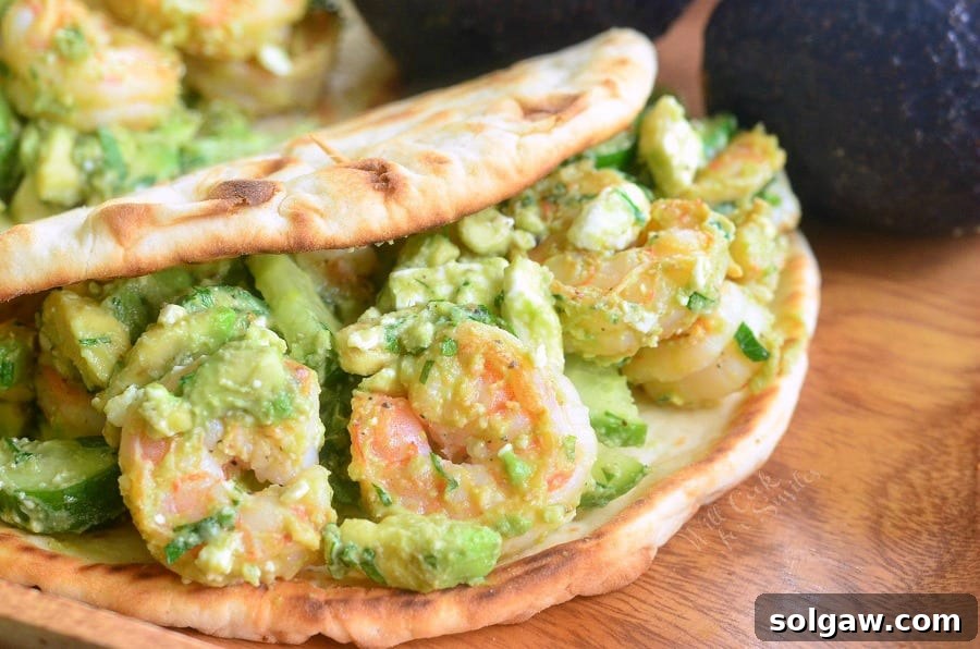 Avocado Shrimp Flatbread Sandwich halves arranged artfully on a wooden cutting board, showcasing the vibrant filling