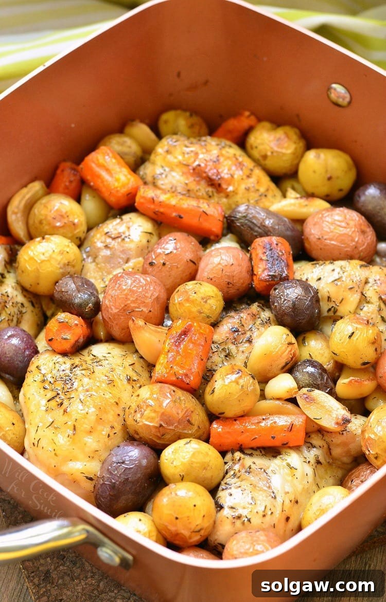 top view photo of Chicken Drumsticks, garlic, potatoes, and carrots in a pan
