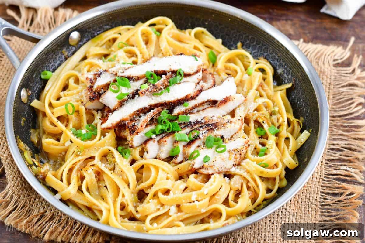 Lemon pepper chicken in a pan with green onions on top as garnish.