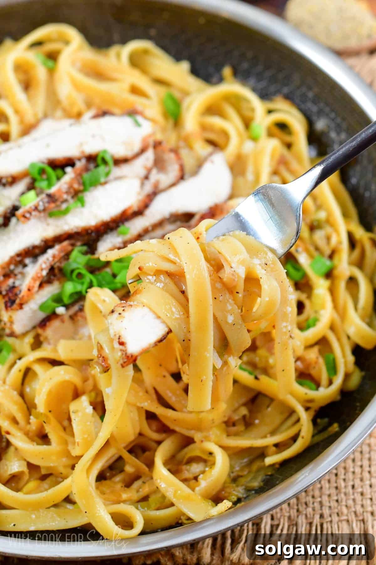 Lemon pepper chicken pasta with pasta swirled onto a fork.