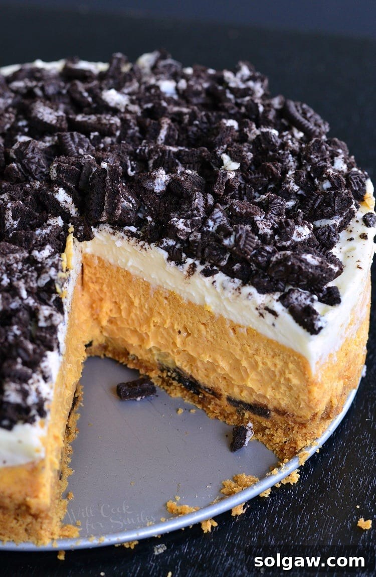 Decadent Layered Oreo Pumpkin Cheesecake 6 Layered Oreo Pumpkin Cheesecake with a slice missing