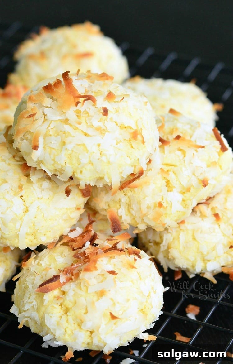 Close-up of fluffy, soft Coconut Pudding Cookies arranged neatly on a metal cooling rack, highlighting their perfect round shape and flake coating.