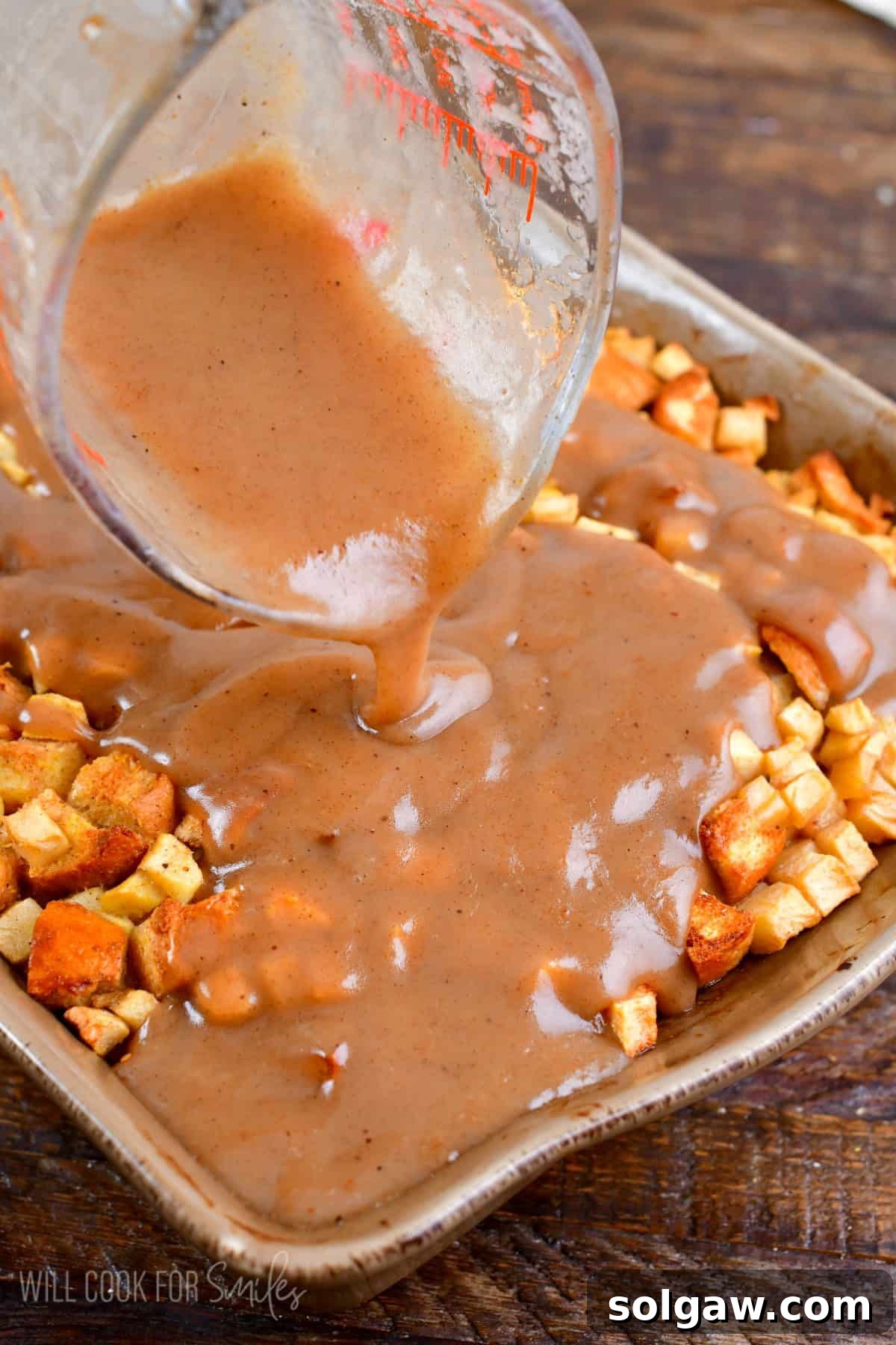 Pouring the saved apple sauce over the warm apple bread pudding straight out of the oven.