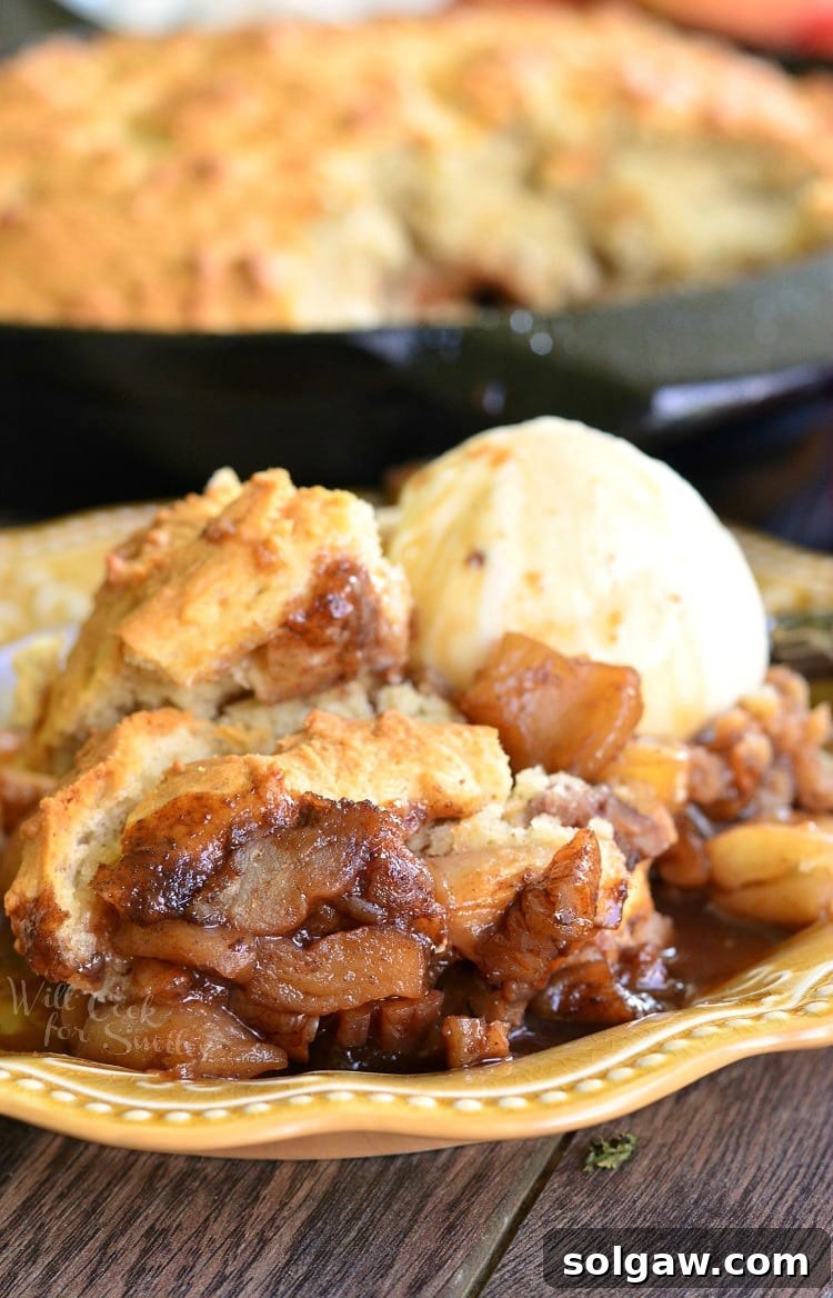 Maple Pecan Apple Cobbler with ice cream on a yellow plate