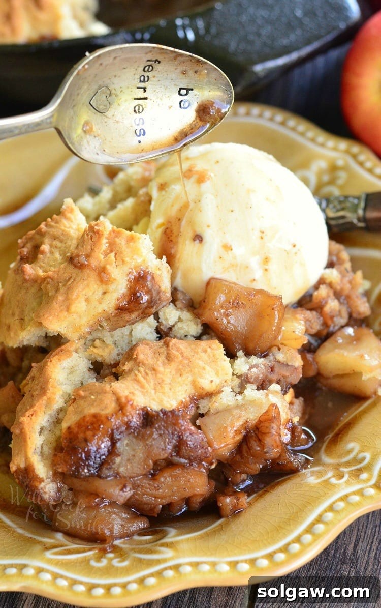 Maple Pecan Apple Cobbler Skillet with a scoop of vanilla ice cream on a yellow plate 