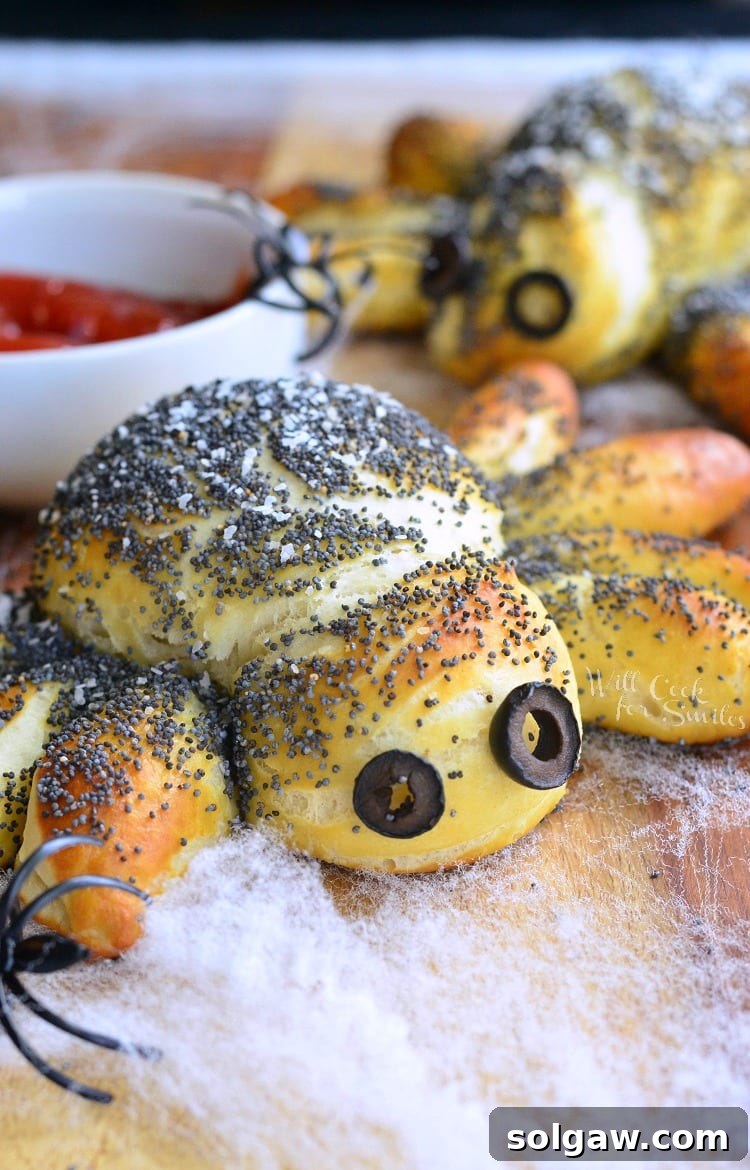 Decorative pretzel spiders on a faux web and a wooden table with plastic spider rings around them.