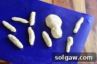 Raw dough shaped like spider parts, ready for assembly.