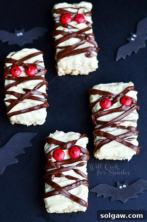 Chocolate Rice Krispie Mummies with red candy eyes, wrapped in white chocolate 