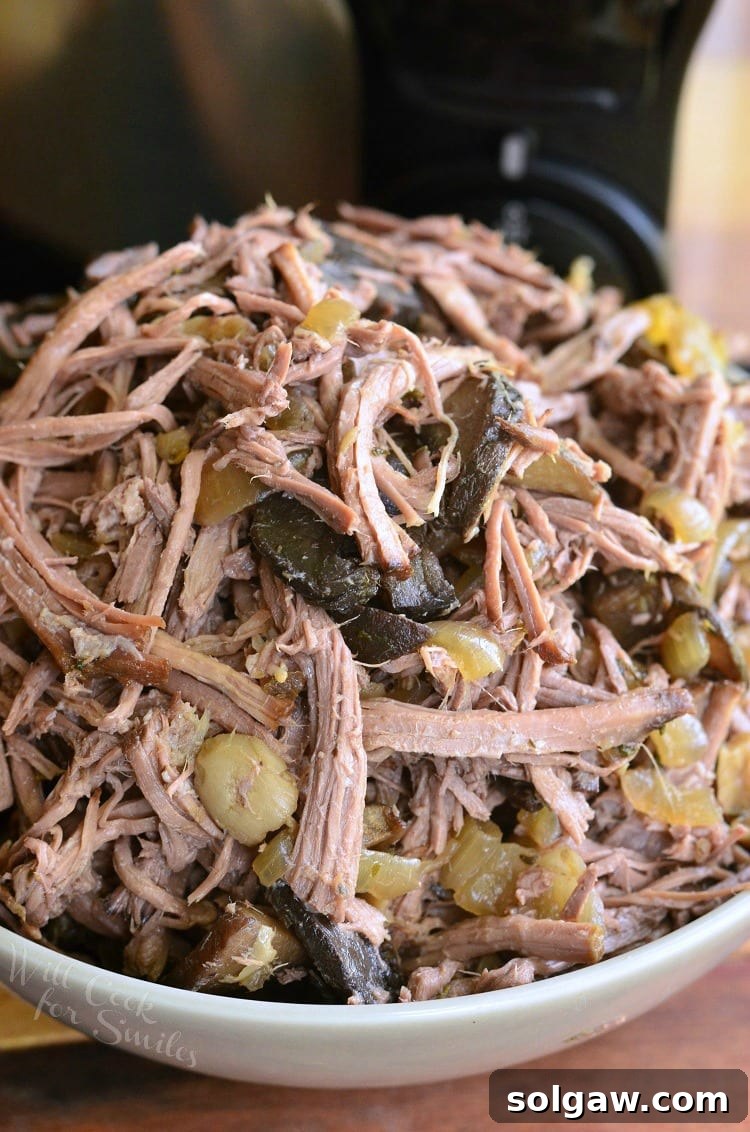 Rich Slow Cooker Mushroom and Onion Italian Beef served in a white bowl, ready to enjoy