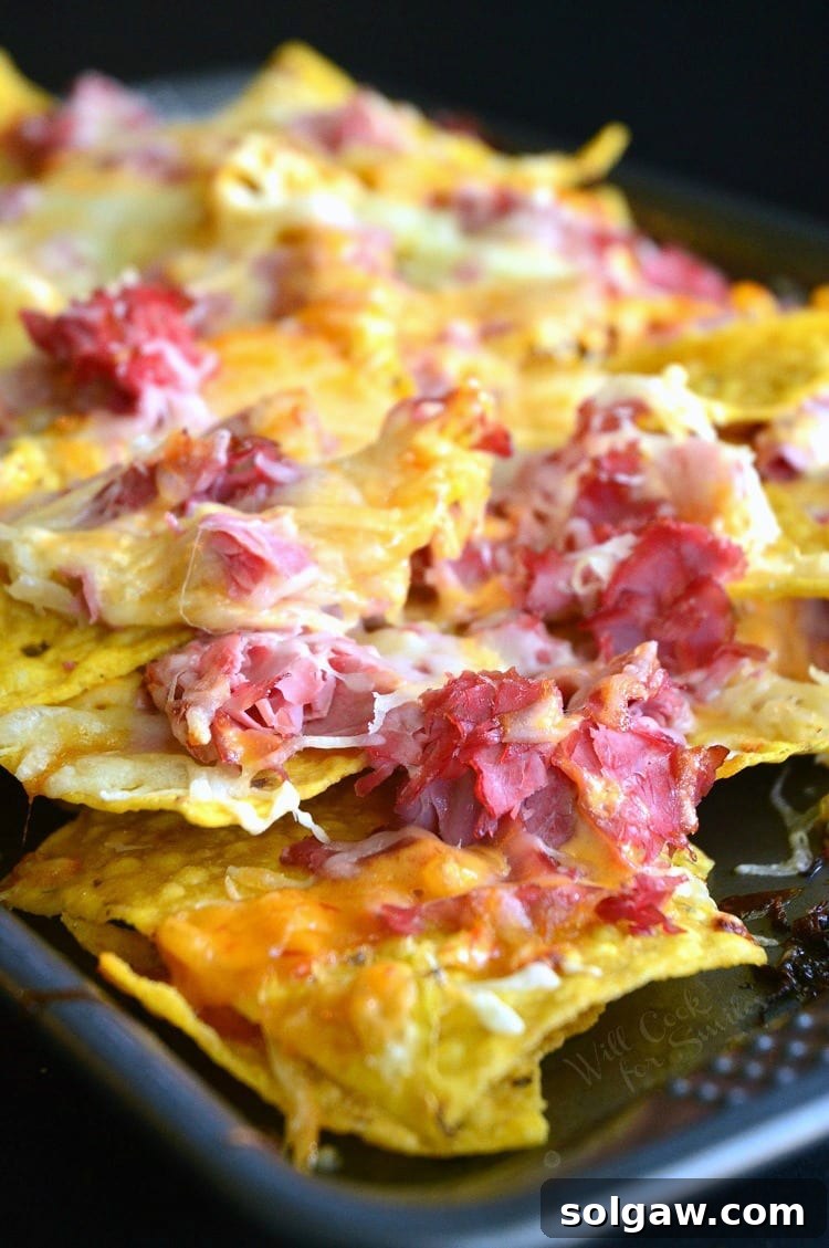Close-up of baked Reuben Nachos with perfectly melted cheese and visible layers of corned beef and sauerkraut