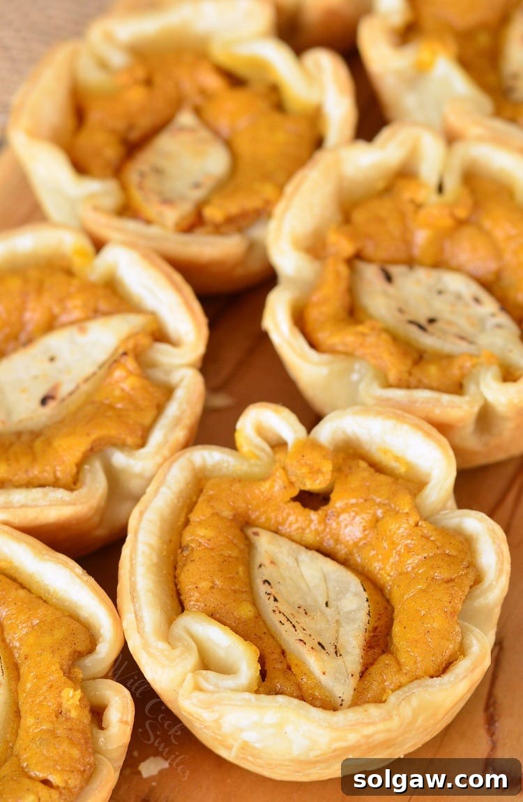 Fall Spiced Pumpkin Cheesecake Bites 3 Top view of Mini Pumpkin Cheesecake Pies on a cutting board