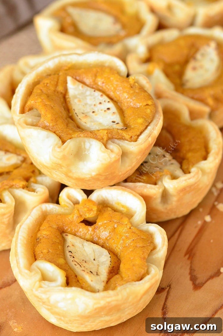 Fall Spiced Pumpkin Cheesecake Bites 7 Mini Pumpkin Cheesecake Pies on a wood cutting board