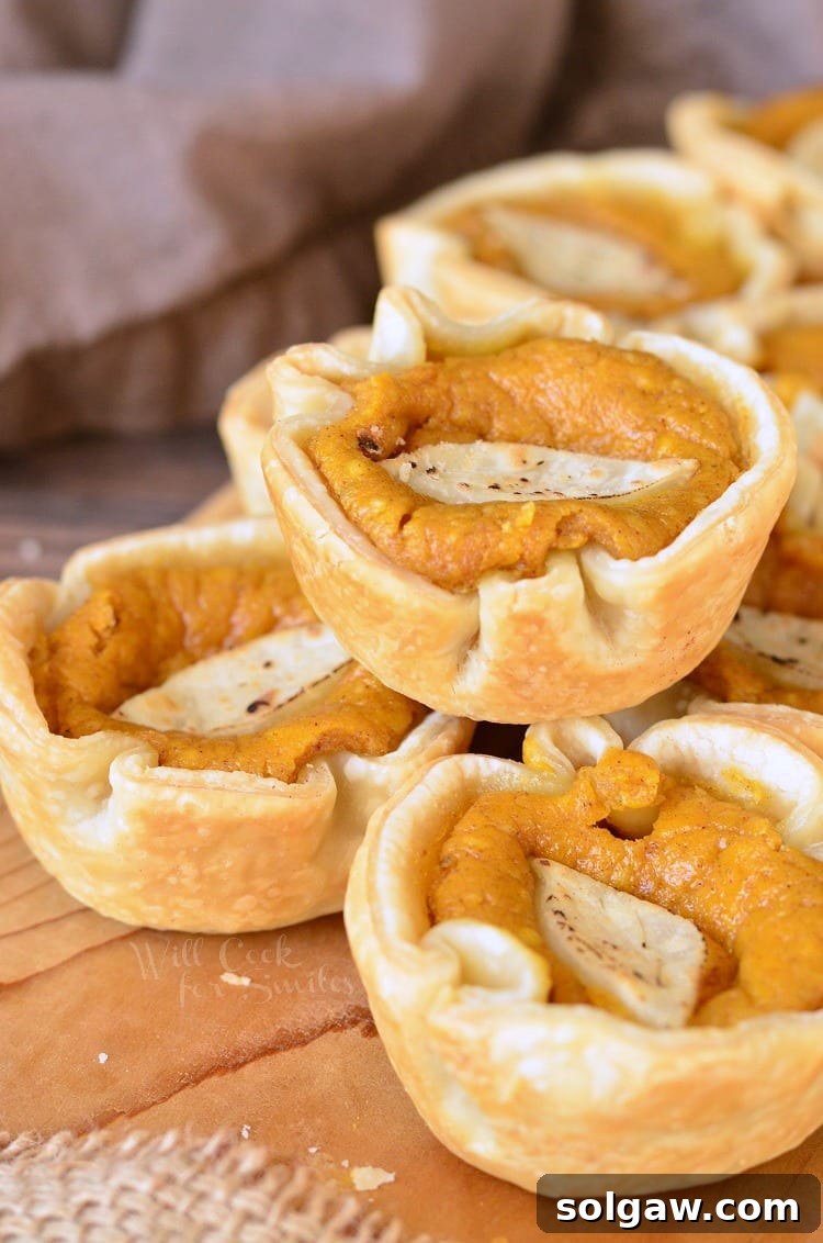 8 mini pumpkin cheesecake pie on a wooden table.