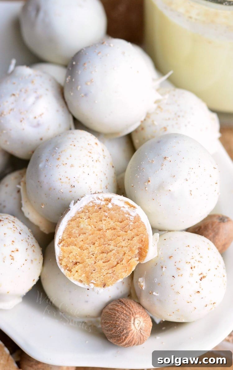 Eggnog Cookie Balls in a white bowl with one cut in half