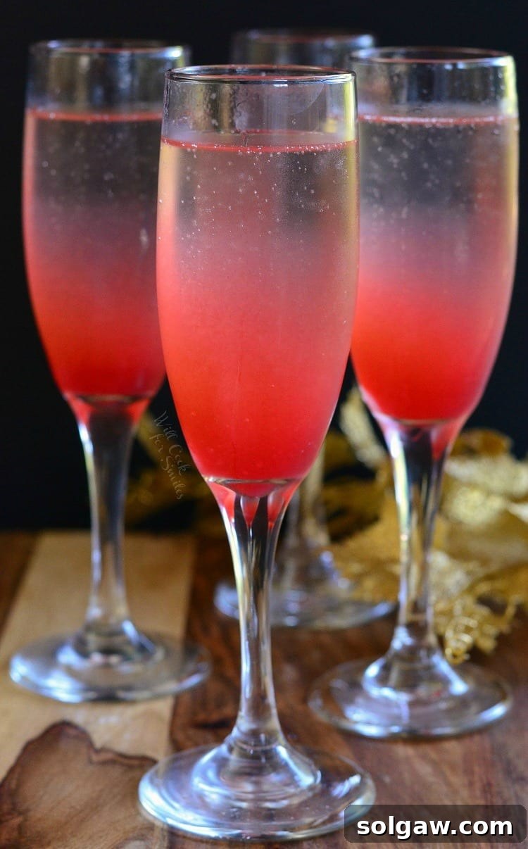 Raspberry Italian Champagne Spritz 2 Three Raspberry Italian Soda Champagne Cocktails in elegant flutes on a pristine table, ready for a toast.