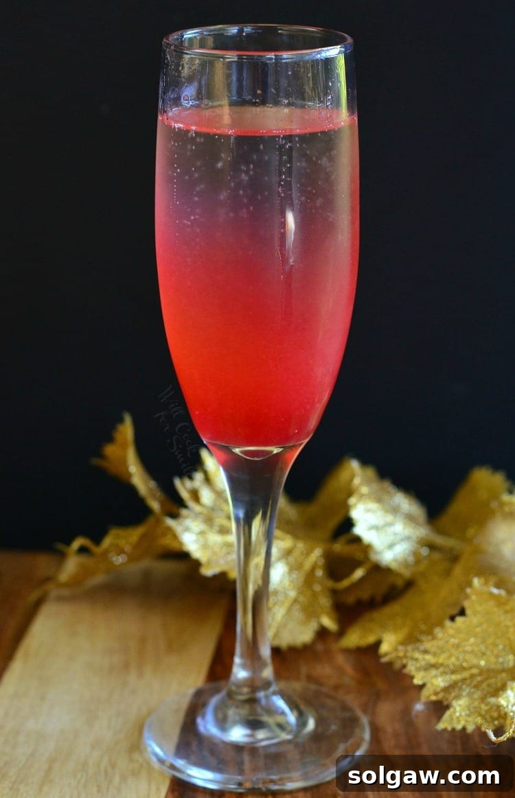 Raspberry Italian Champagne Spritz 5 A Raspberry Italian Soda Champagne Cocktail in a flute, showcasing its inviting appearance on a table, ready to be enjoyed.