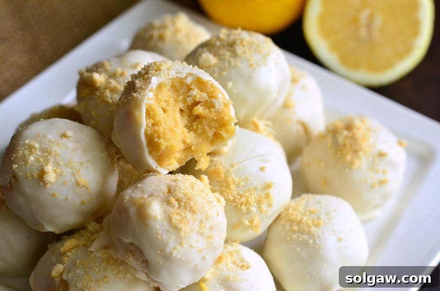 Zesty Coconut Oreo Delights 4 Lemon Oreo Coconut Cookie Truffles on a white plate with a bit taken out