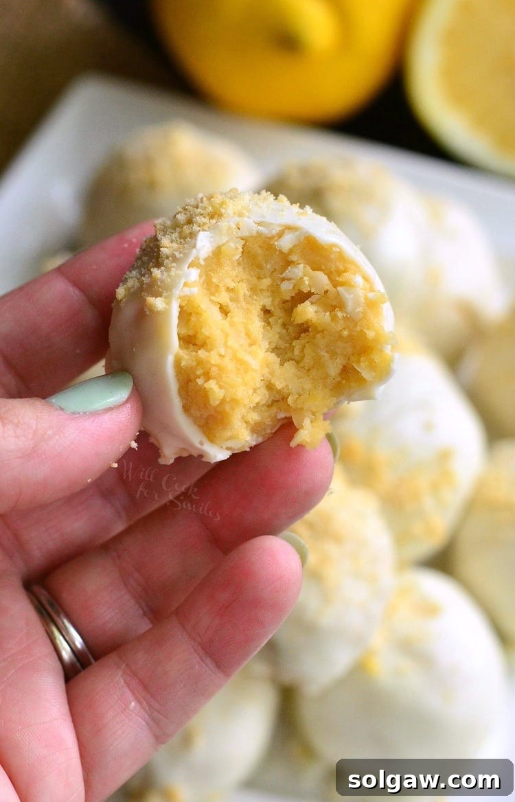 Zesty Coconut Oreo Delights 7 holding Lemon Oreo Coconut Cookie Truffles that have a bite taken out of them