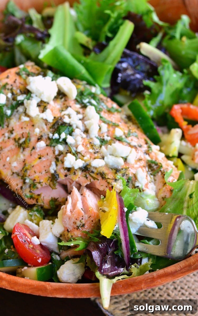 Overhead shot of a bountiful Greek Salmon Salad in a wooden bowl