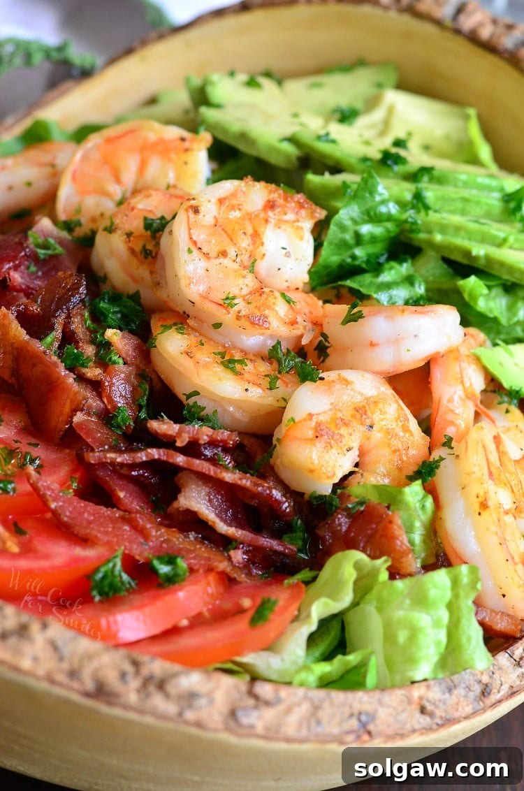 Delicious Shrimp BLTA Salad with creamy avocado in a rustic bowl