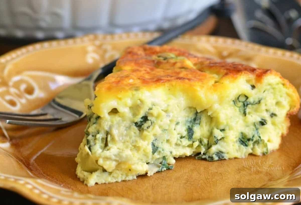A perfectly cooked slice of spinach artichoke crustless quiche on a brown plate, ready to eat.