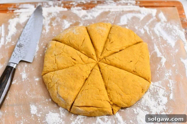 cutting pumpkin dough into triangles for a scone recipe