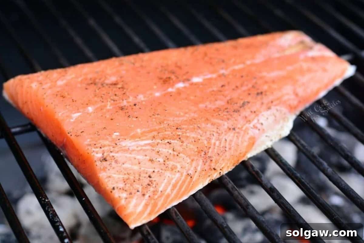 salmon filet seasoned with salt and pepper on the grill.
