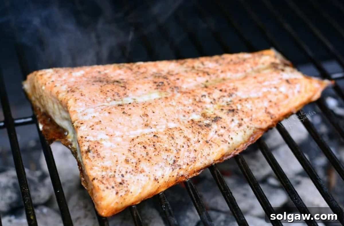 grilled salmon filet on the grill with smoke coming off.