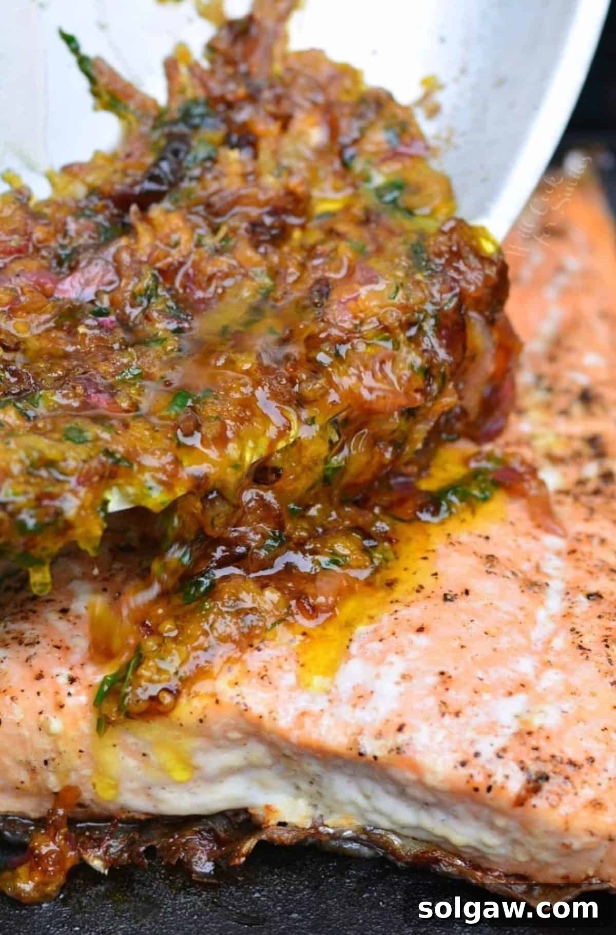 pouring brown butter citrus sauce over the grilled salmon.