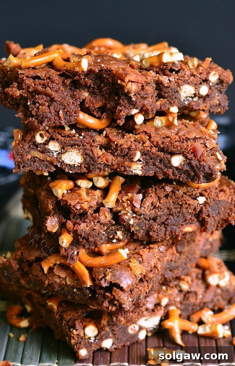 Pretzel Bacon Brownies stacked on a plate, showcasing their gooey texture and crispy toppings