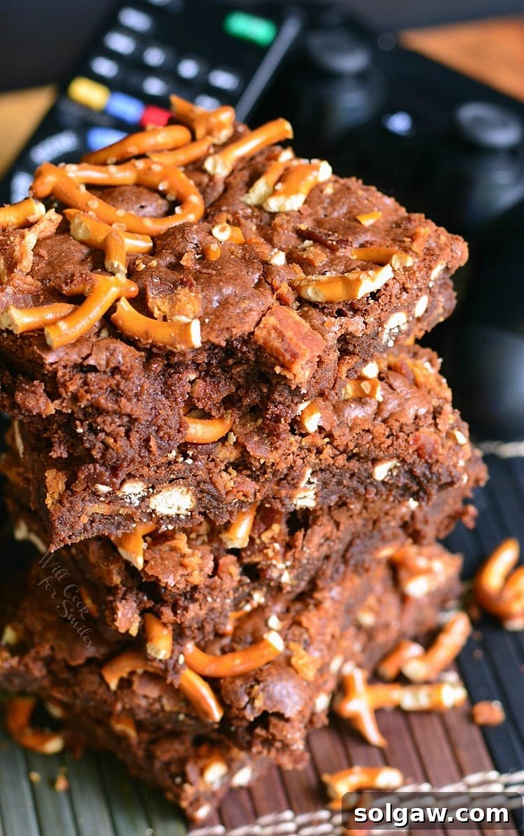 Close-up of a single Pretzel Bacon Brownie, showcasing its fudgy interior and crunchy toppings