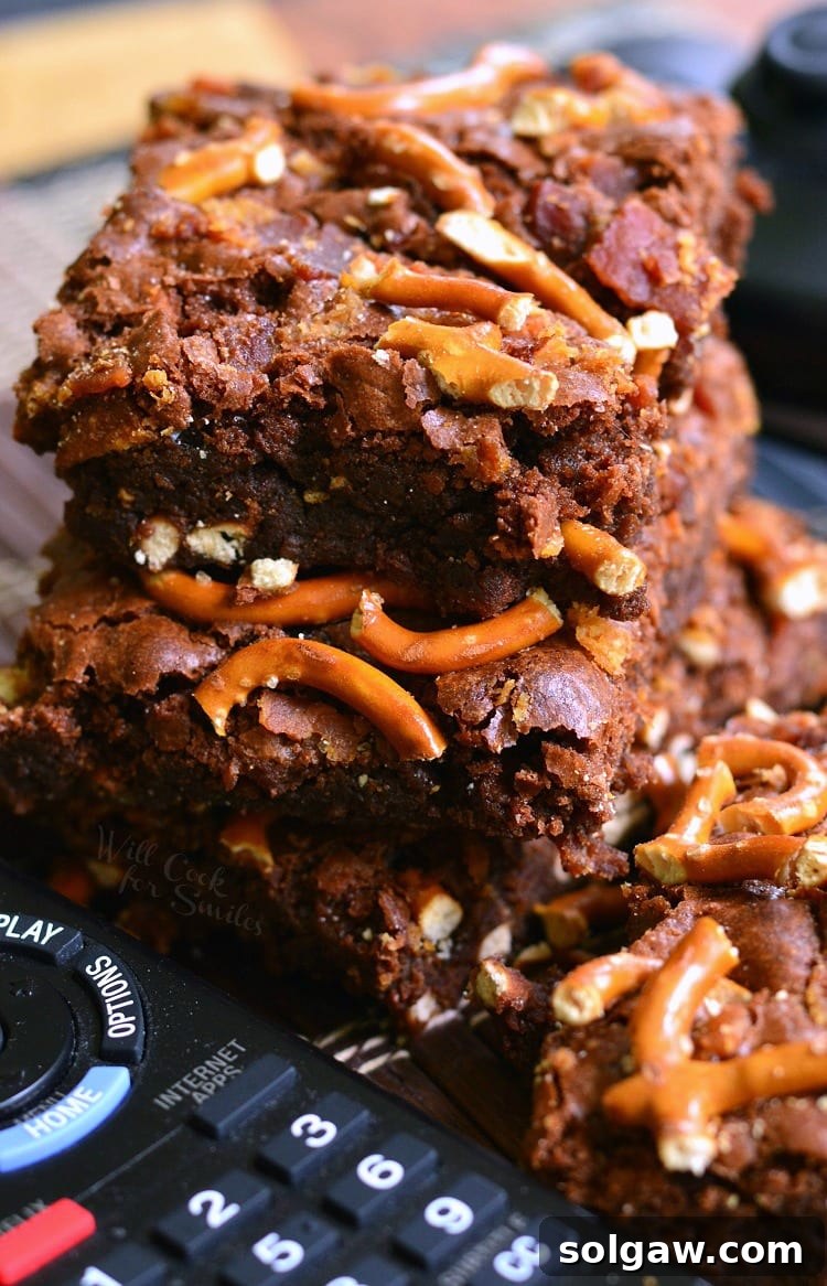 Pretzel Bacon Brownies on a rustic wooden table with a remote control, emphasizing comfort food