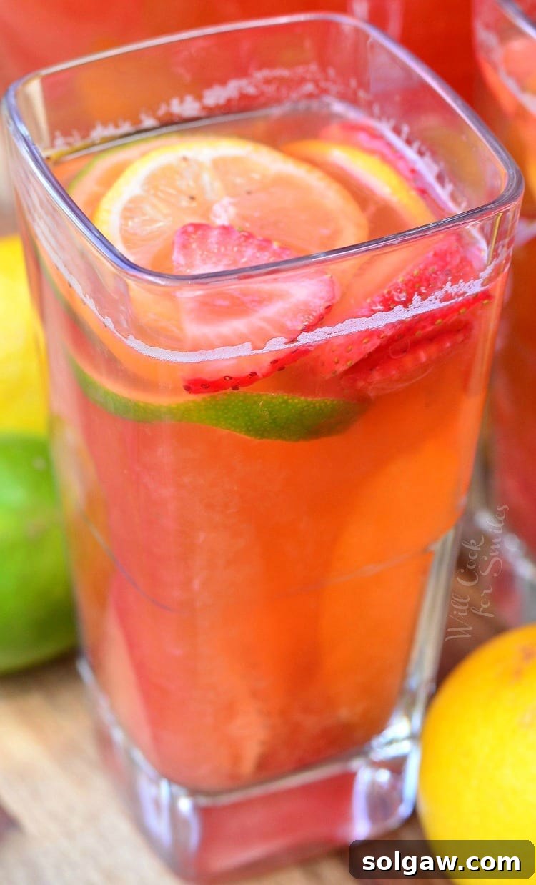 Strawberry Lemon Lime Lemonade in glass with lemon, lime, strawberry garnish