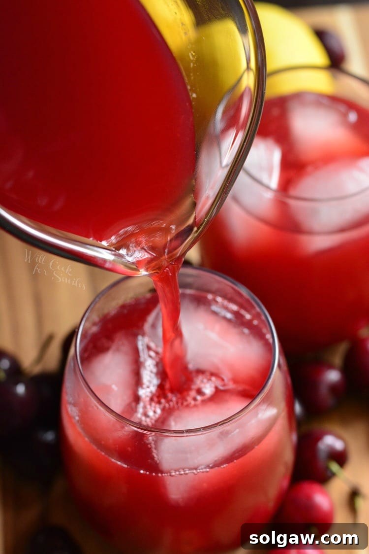 top view of pouring Homemade Cherry Arnold Palmer from pitcher into glass