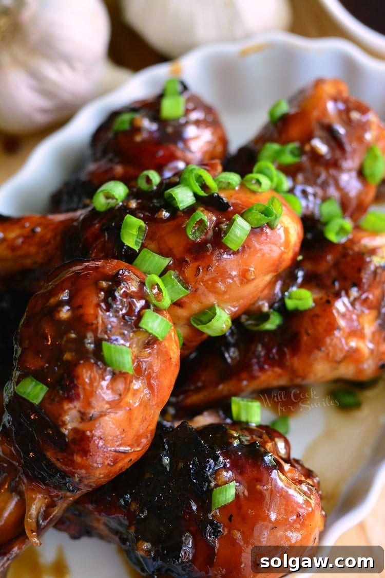Sweet Garlic Grilled Chicken Drumsticks artfully arranged on a serving platter, glistening with glaze and garnished for presentation.