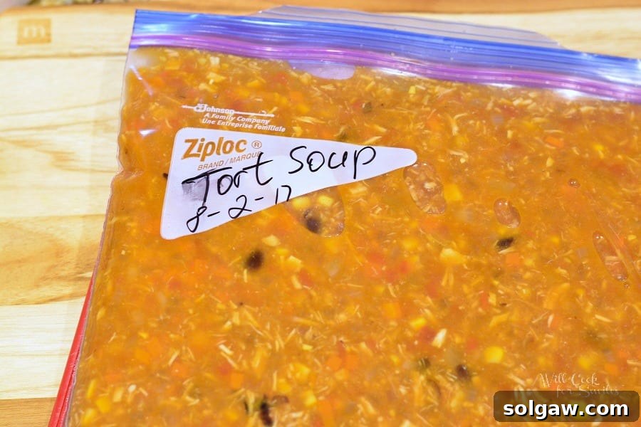 Chicken Tortilla Soup in a freezer bag on a wood cutting board 