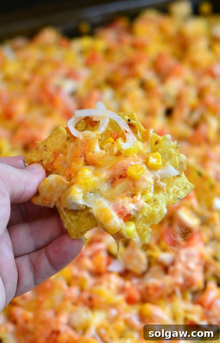 Holding a nacho from the sheet pan.
