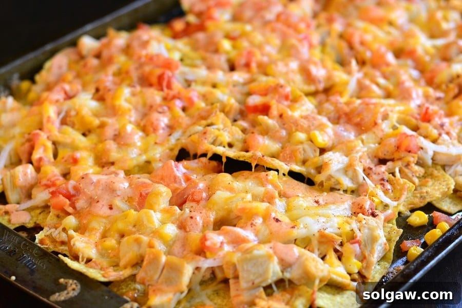 horizonal photo of nachos on a sheet pan.
