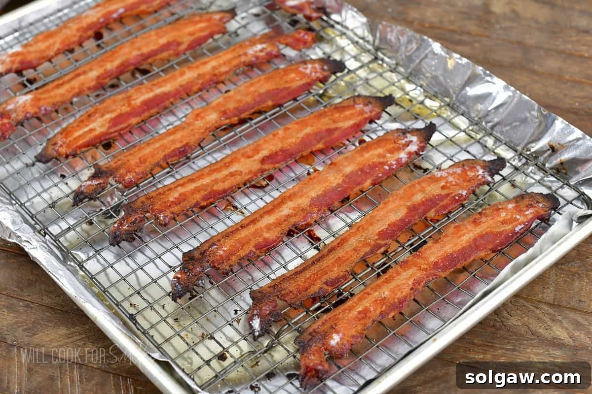 cooked bacon on a wire rack inside a rimmed tray.