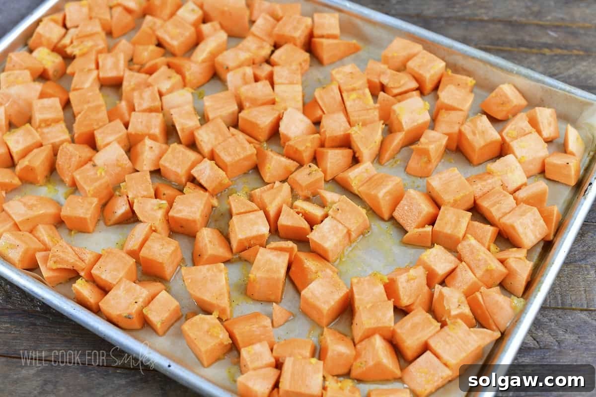 seasoned sweet potatoes on a baking tray.