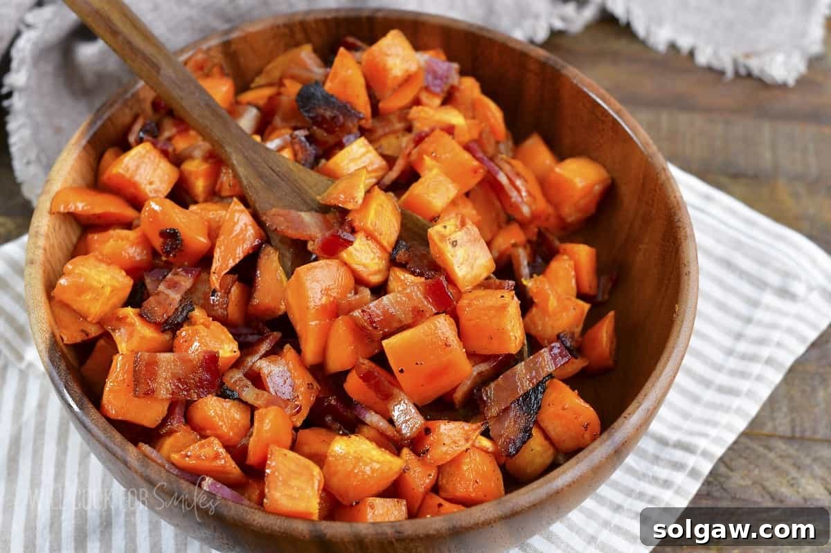 spooning out some roasted sweet potatoes from the bowl.