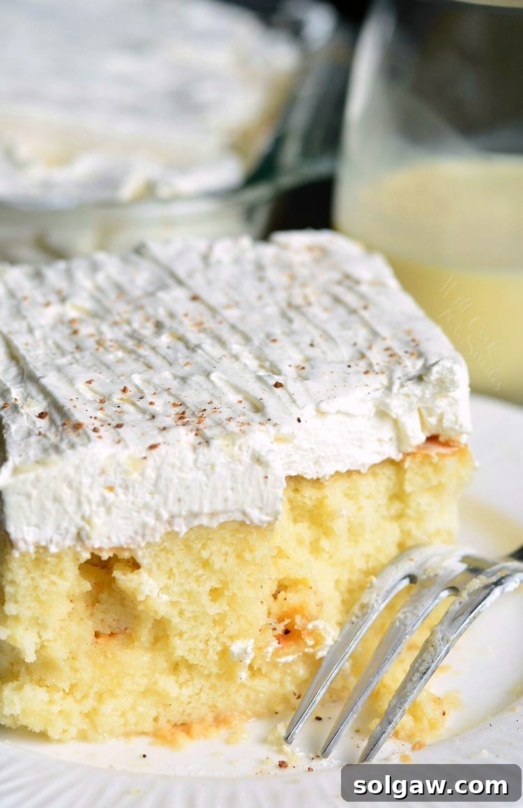 Another perspective of a slice of Eggnog Poke Cake, showcasing its festive appeal.