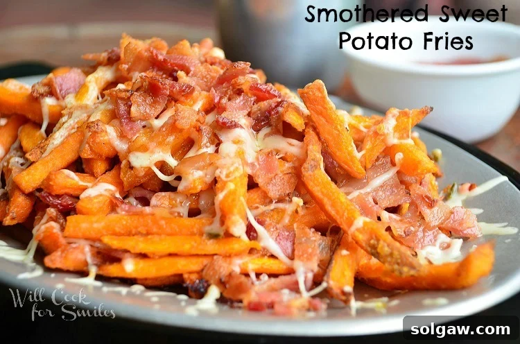 Close-up shot of irresistible smothered sweet potato fries, generously topped with melted pepper jack cheese and crispy bacon, served with a side of white sauce