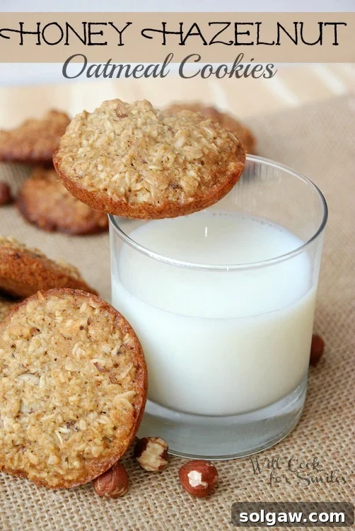 Honey Hazelnut Oatmeal Cookies arranged on a burlap cloth with a glass of milk