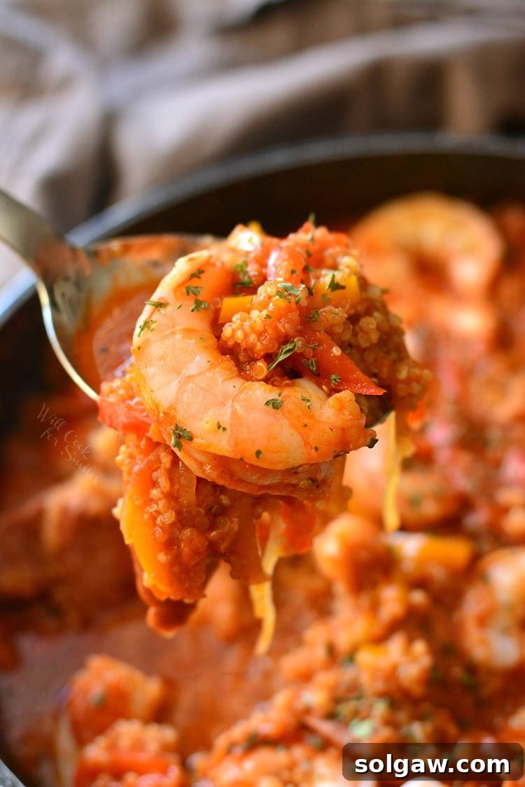 Smoked Sausage and Shrimp Jambalaya with Quinoa in a pan with a spoon scooping some out