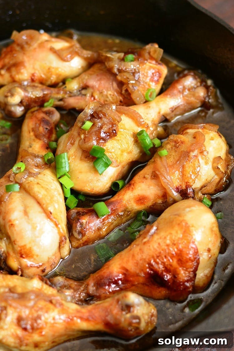 Honey Guinness Chicken Drumsticks in a pan, garnished with herbs