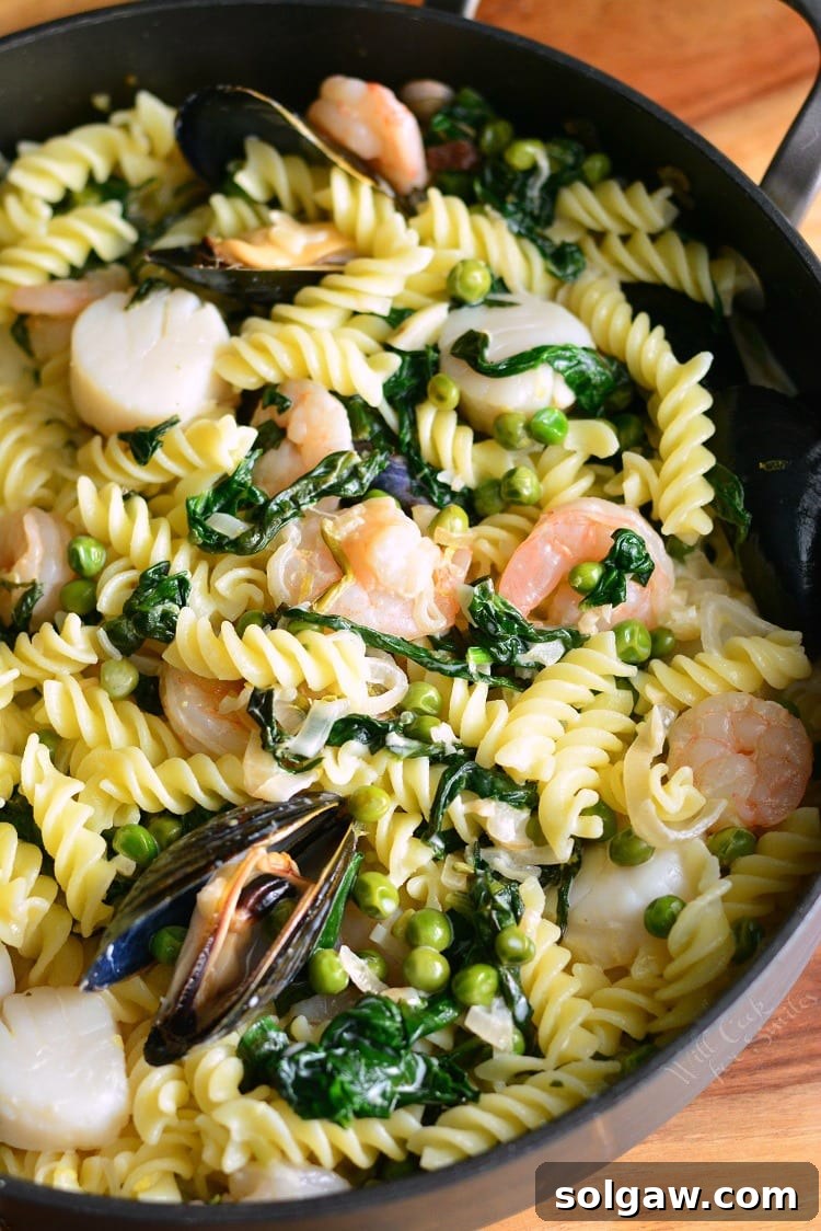 Creamy Spinach and Peas Seafood Pasta in a pan, freshly cooked and ready to serve