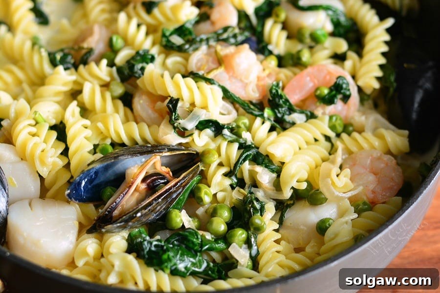 Creamy Spinach and Peas Seafood Pasta plated and ready to eat, garnished with fresh herbs