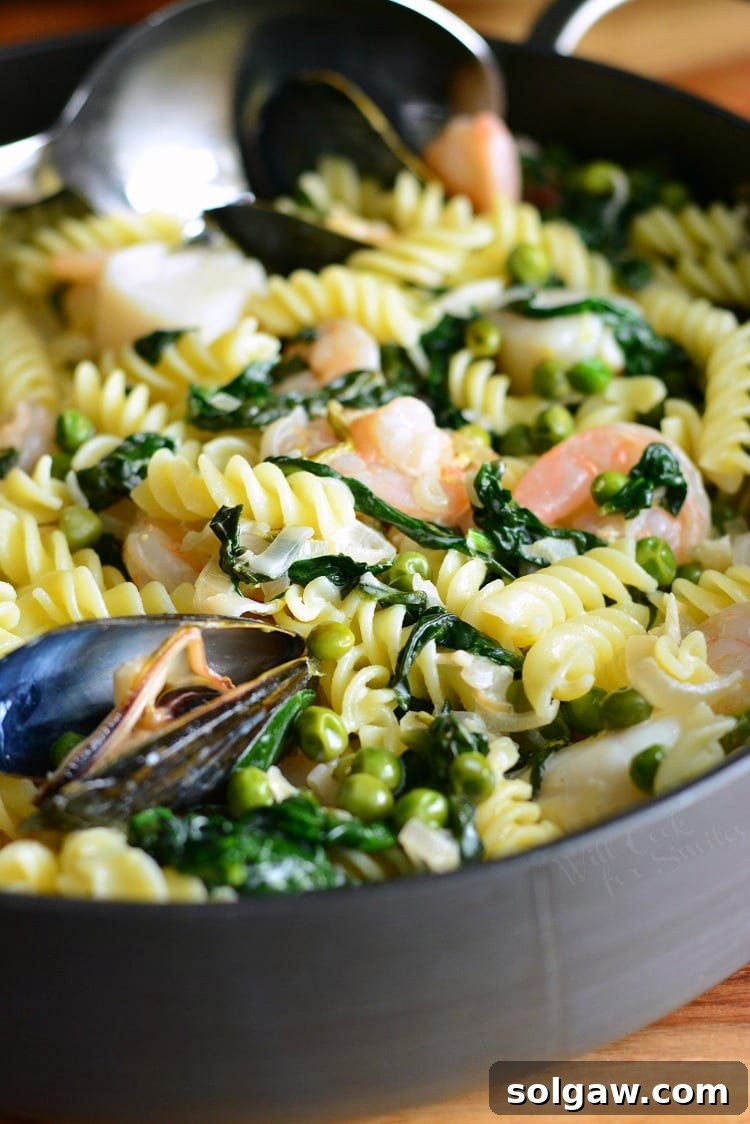 Close-up view of Creamy Spinach and Peas Seafood Pasta in a pan, highlighting the creamy texture and fresh ingredients