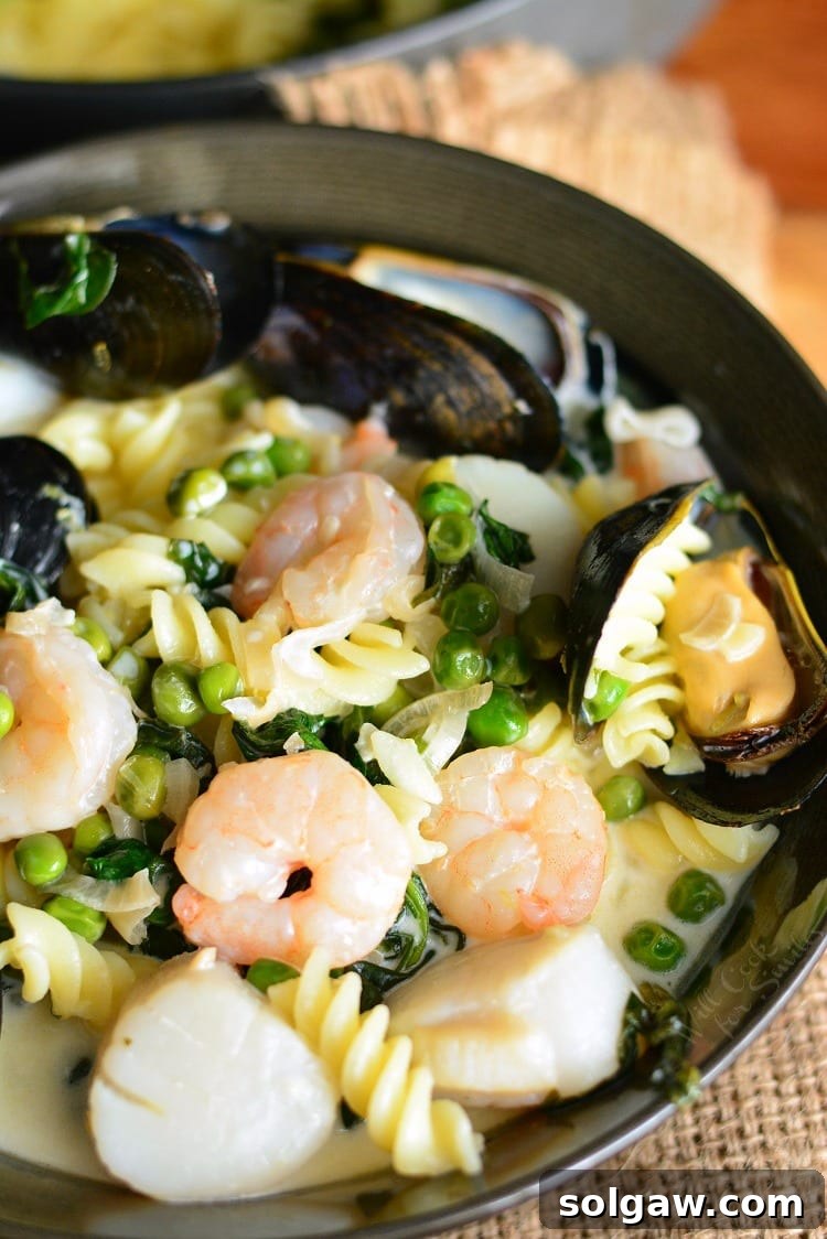 Delicious Creamy Spinach and Peas Seafood Pasta in a skillet, ready to be served